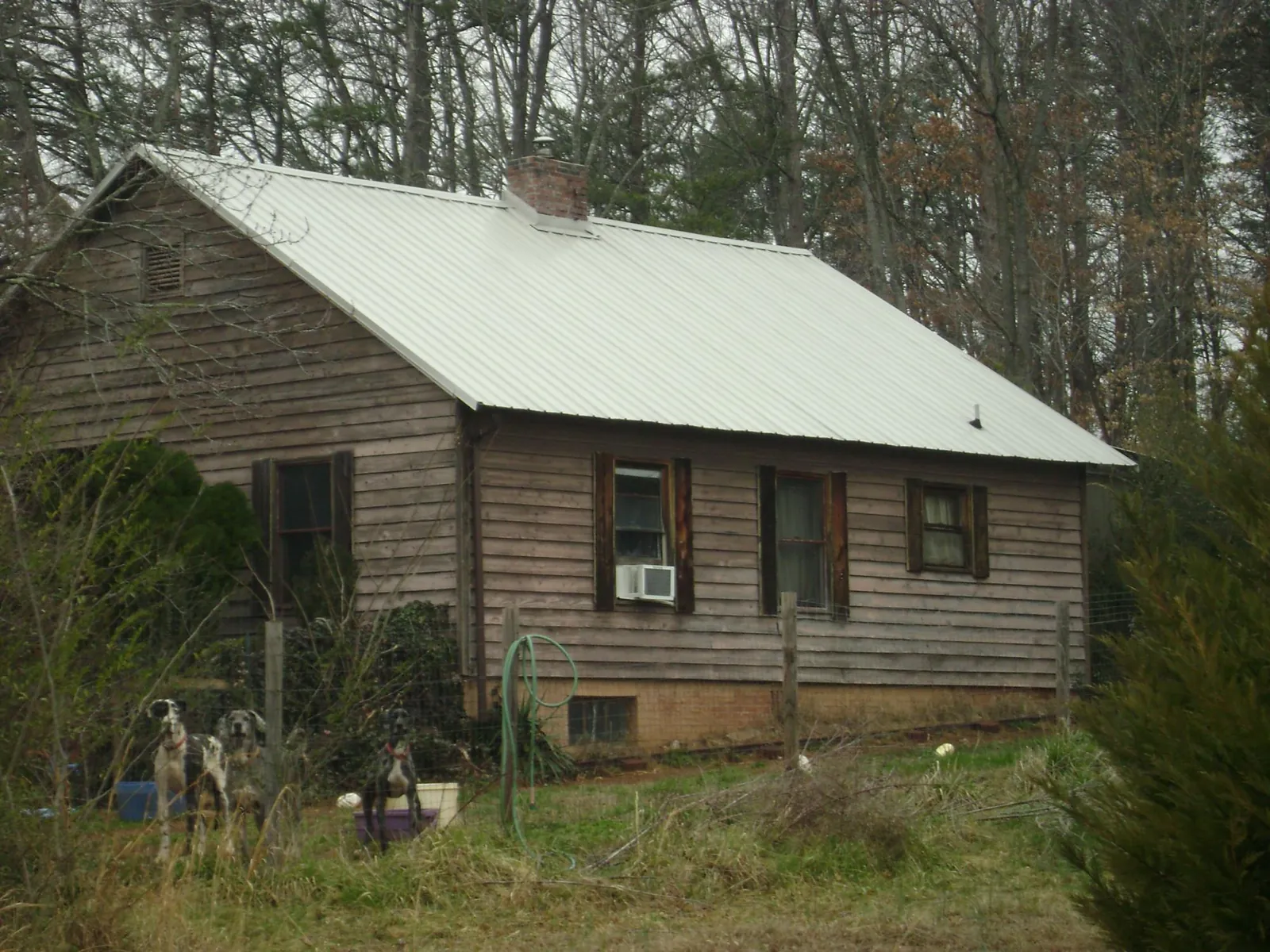 White metal roof on an old wood sided farmhouse, from a Metal Roof Installation job in National City